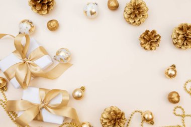 Beyaz hediyeler, altın fiyonklar ve bej arka planda ışıldayan süslemelerle süslü bir kış düzeni. Tebrik kartları, web pankartları ya da markalar için mükemmel.