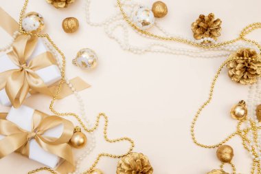 Beyaz hediyeler, altın fiyonklar ve bej arka planda ışıldayan süslemelerle süslü bir kış düzeni. Tebrik kartları, web pankartları ya da markalar için mükemmel.