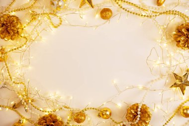 Beyaz yüzeyde altın süsleri ve çam kozalaklarıyla parıldayan sıcak peri ışıkları. Konforlu ışıklandırma ve merkezi fotokopi alanı ile minimum tatil kompozisyonu, mevsimlik kartlar ve davetiyeler için ideal.