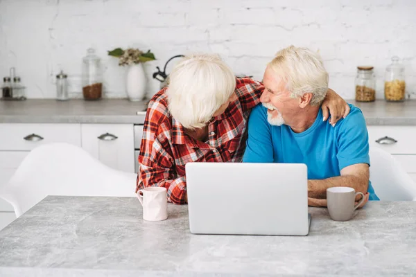 Старша пара з ноутбуком вдома — стокове фото