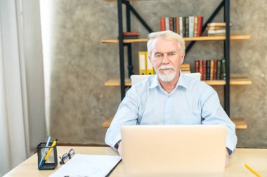 Üstün gri saçlı, şık giyinmiş bir adam.