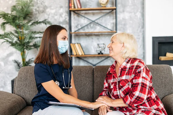 Doctor in medical mask and patient at home.