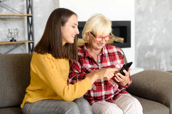 Mujeres jóvenes y mayores con un smartphone —  Fotos de Stock