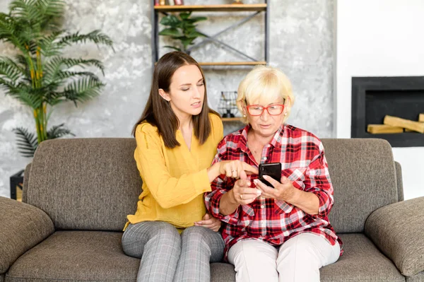 Mujeres jóvenes y mayores con un smartphone —  Fotos de Stock