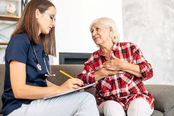 A doctor consulting senior female patient at home