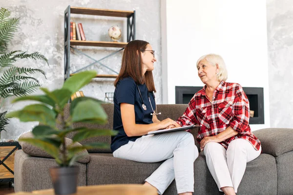 A doctor consulting senior female patient at home