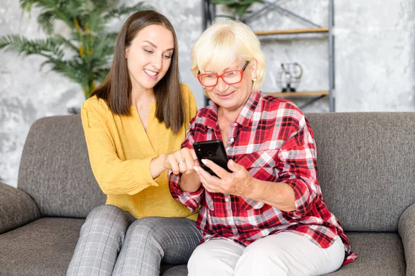 Mujeres jóvenes y mayores con un smartphone —  Fotos de Stock