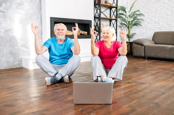 Seniorenpaar praktiziert Yoga mit Laptop — Stockfoto