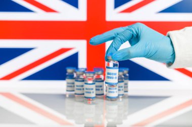 Kauçuk eldivendeki bir el covid aşıyı tutar.