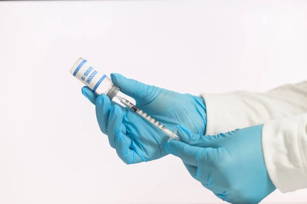 As mãos de um médico de luvas enchem uma seringa — Fotografia de Stock