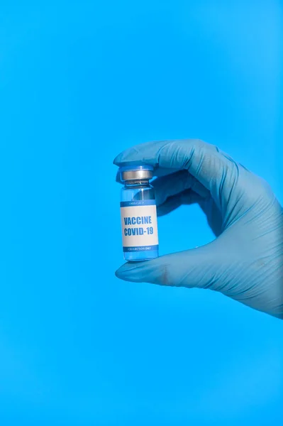 Hand van een medicus in handschoen houdt een vaccin vast — Stockfoto