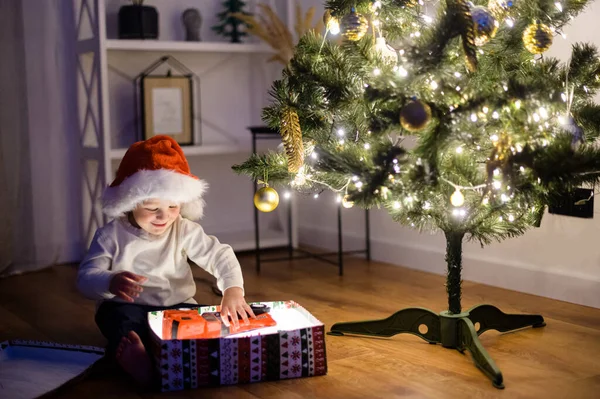 Un garçon mignon avec une boîte cadeau près de l'arbre de Noël — Photo