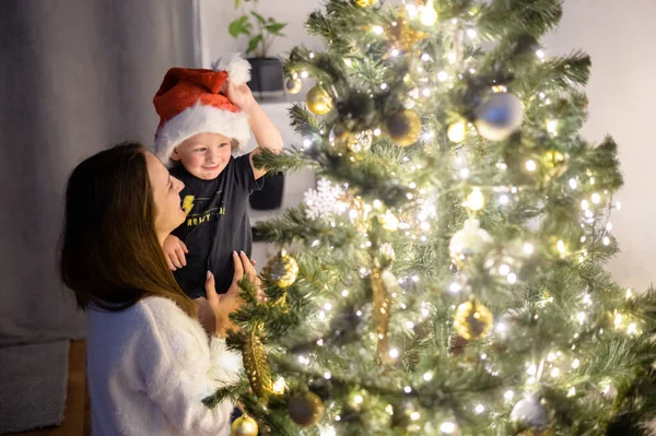 En mor och en son nära en julgran — Stockfoto