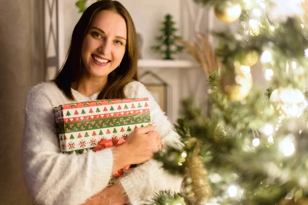 Une femme avec une boîte cadeau près de l'arbre de Noël — Photo
