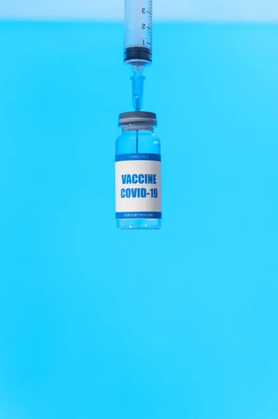 The syringe is stuck in the bottle of covid vaccine