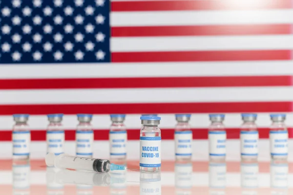 Um monte de frascos de vacina na bandeira americana — Fotografia de Stock