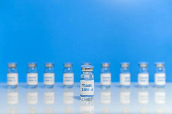 Frascos para injetáveis de vacina contra o coronavírus isolados em azul — Fotografia de Stock