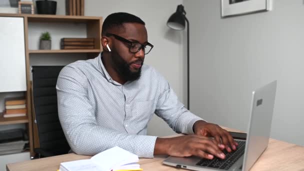 En afrikansk kille använder laptop för arbete — Stockvideo