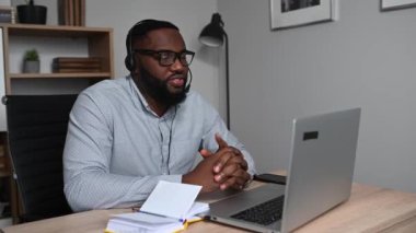 Afrikalı bir adam iş için kulaklık kullanıyor.