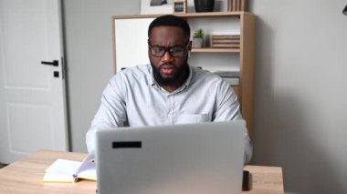 Canı sıkkın bir adam laptopta şaşkın şaşkın bakıyor.