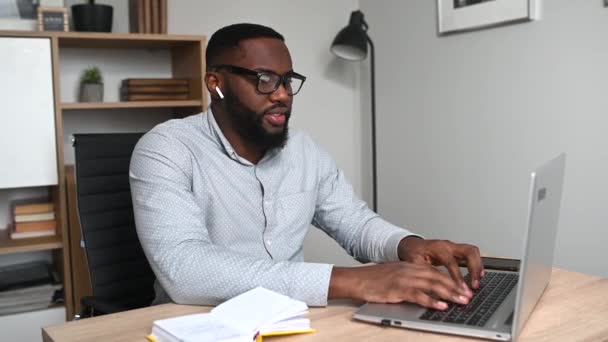 Een Afrikaan gebruikt laptop voor werk. — Stockvideo