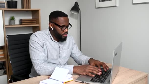 Un ragazzo africano sta usando il computer portatile per lavoro — Video Stock