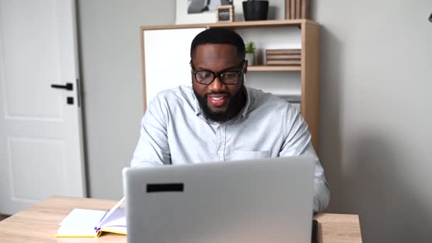 En afrikansk kille använder laptop för arbete — Stockvideo