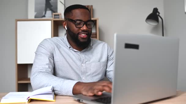 Один африканець використовує ноутбук для роботи. — стокове відео
