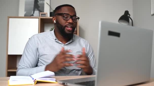 Een Afro-Amerikaanse man die laptop videogesprekken gebruikt — Stockvideo