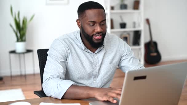 Un africano está usando un portátil para trabajar — Vídeos de Stock