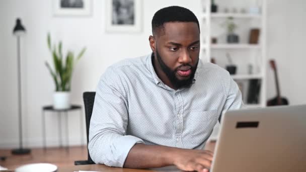 Een geïrriteerde man kijkt verbaasd op de laptop — Stockvideo