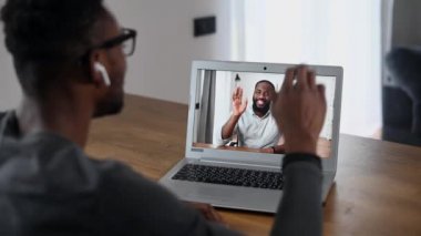 Video görüşmesi için laptop kullanan Afrikalı bir adam.