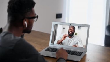 Video görüşmesi için laptop kullanan Afrikalı bir adam.
