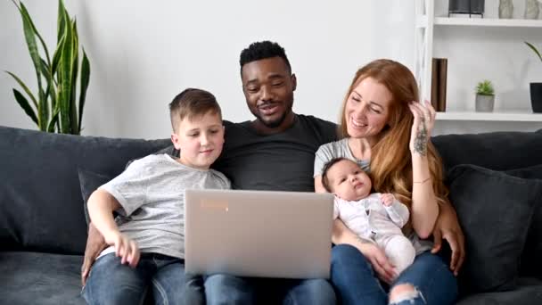 Een multiraciale familie van vier heeft een videogesprek. — Stockvideo