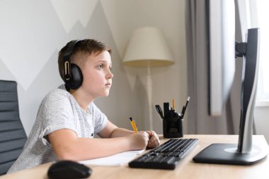 Okul çocuğu internette video dersleri izliyor.