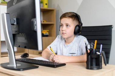 Okul çocuğu internette video dersleri izliyor.
