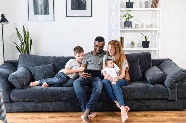 A multiracial family on the couch at home clipart