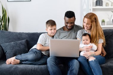Evdeki koltukta çok ırklı bir aile.