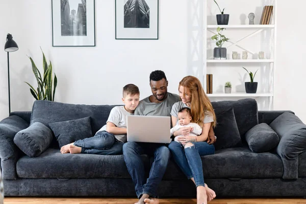 Una familia multirracial en el sofá en casa — Foto de Stock