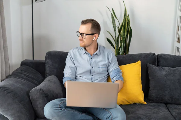 Un tipo freelancer está usando un portátil en casa — Foto de Stock