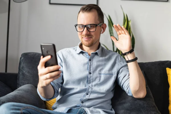 Un tipo con un teléfono inteligente hablando en línea — Foto de Stock