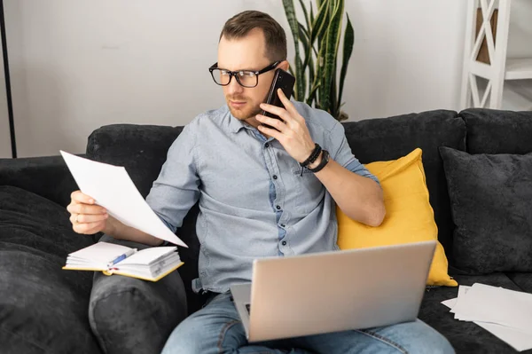 Een freelancer met een laptop die papierwerk doet — Stockfoto