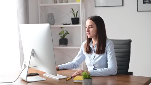 Μια νεαρή γυναίκα χρησιμοποιεί υπολογιστή στο γραφείο. — Αρχείο Βίντεο