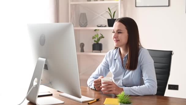 Een jonge vrouw gebruikt PC in het kantoor — Stockvideo