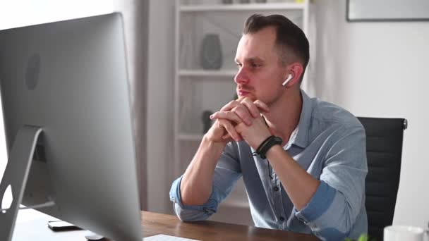 Ein junger Mann arbeitet mit einem PC im Büro — Stockvideo