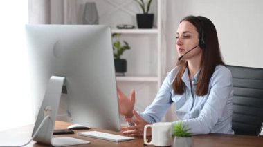 Kulaklıklı bir kadın internette konuşuyor.