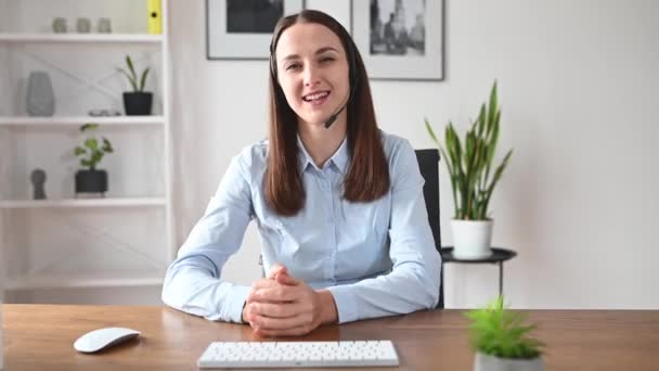 Een vrouw met een headset praat online — Stockvideo