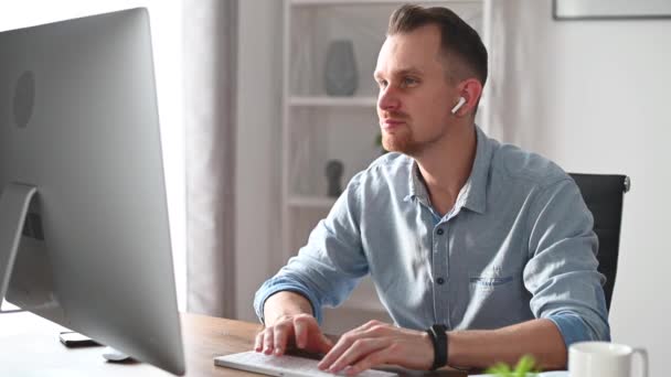 Ein junger Mann arbeitet mit einem PC im Büro — Stockvideo