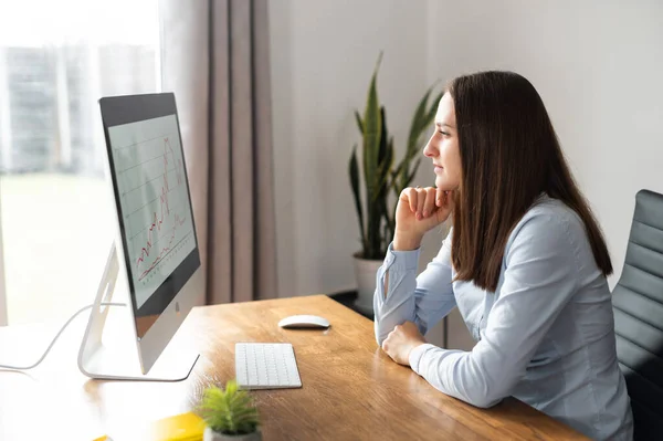 Молодая женщина пользуется компьютером в офисе — стоковое фото