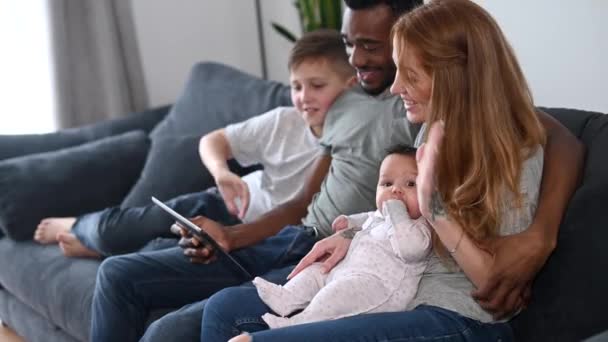 En lycklig multiracial familj på fyra med en tablett — Stockvideo